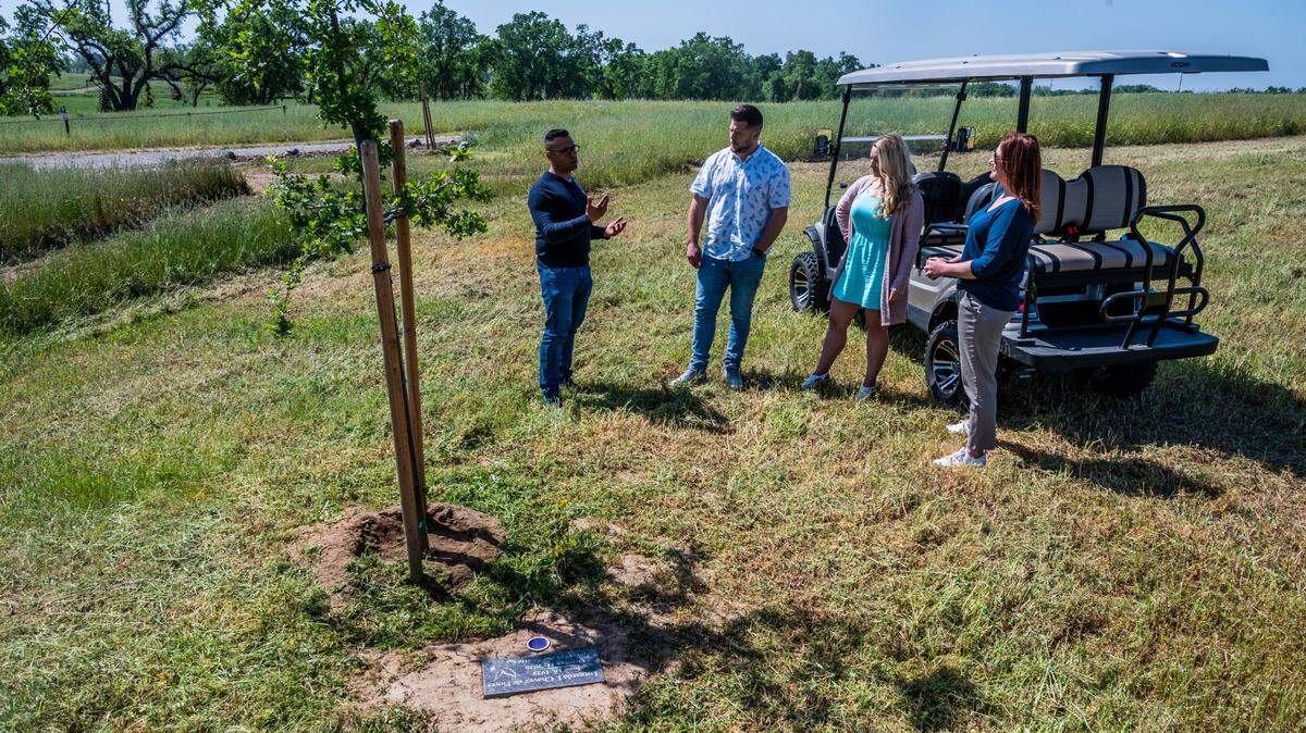 Prospective clients look at a gravestone at Morgan Oaks Eternal Preserve in Lincoln on Earth Day in 2021. California will allow human composting as an alternative to cremation or burial under a new law signed by Gov. Gavin Newsom.