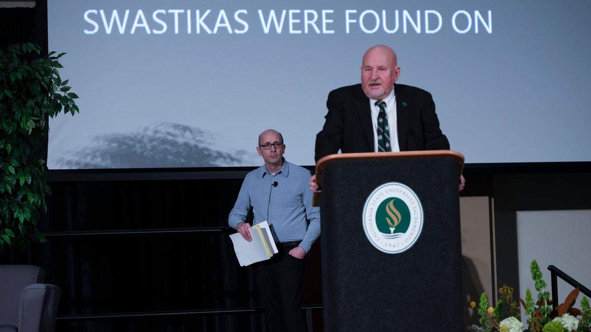 Sacramento State President Robert Nelson speaks as his words are projected on a screen behind him during a campus town hall meeting on Wednesday, Nov. 9, 2022, about antisemitic symbols and hate language reported on and near campus in September. Behind him stands moderator Harvey Stark, chair of the department of humanities and religious studies.