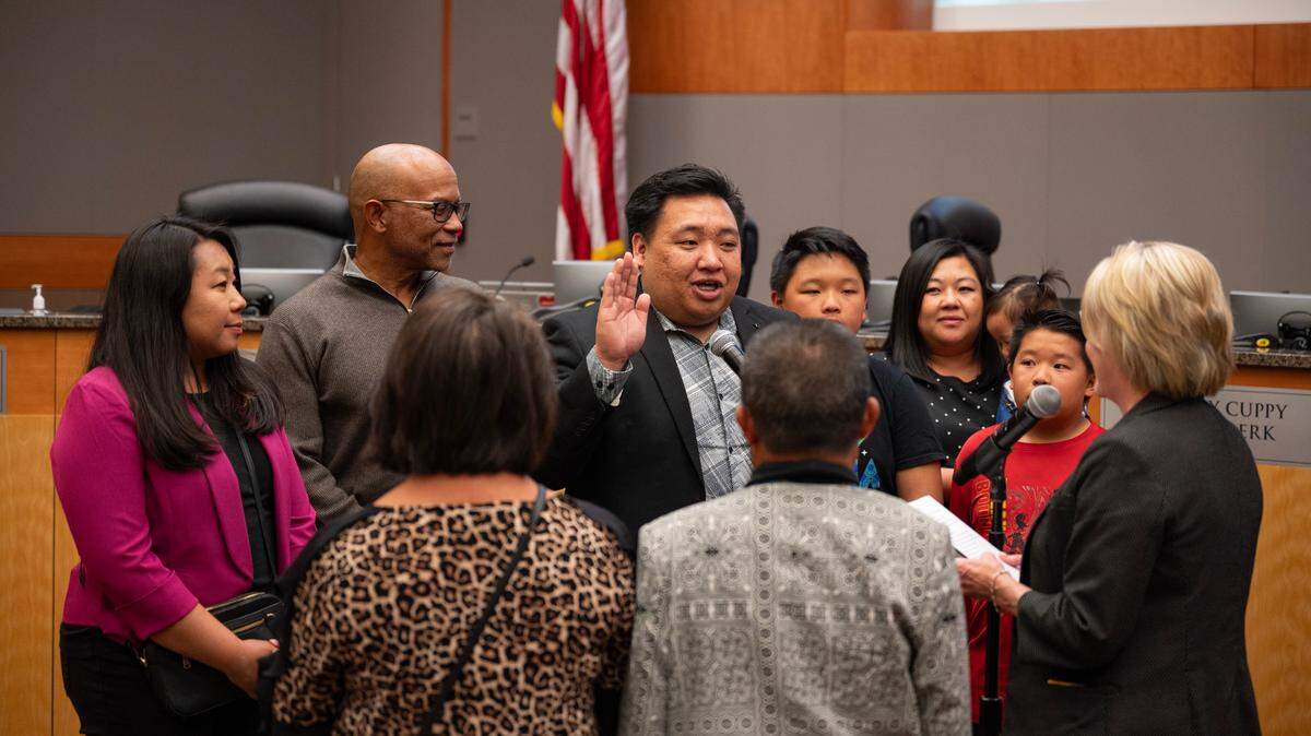 Interim District 2 Sacramento City Councilman Shoun Thao, joined by family members and former Councilman Allen Warren, is sworn-in by City Clerk Mindy Cuppy on Tuesday, April 2, 2024. Thao worked as a city staffer for Warren.