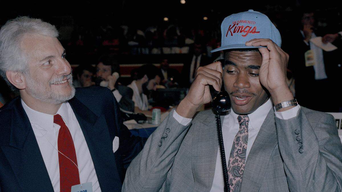 The Kings' No. 1 draft choice, Pervis Ellison, adjusts his new cap in New York on June 28, 1989, as Kings representative Jim Kerman smiles.
