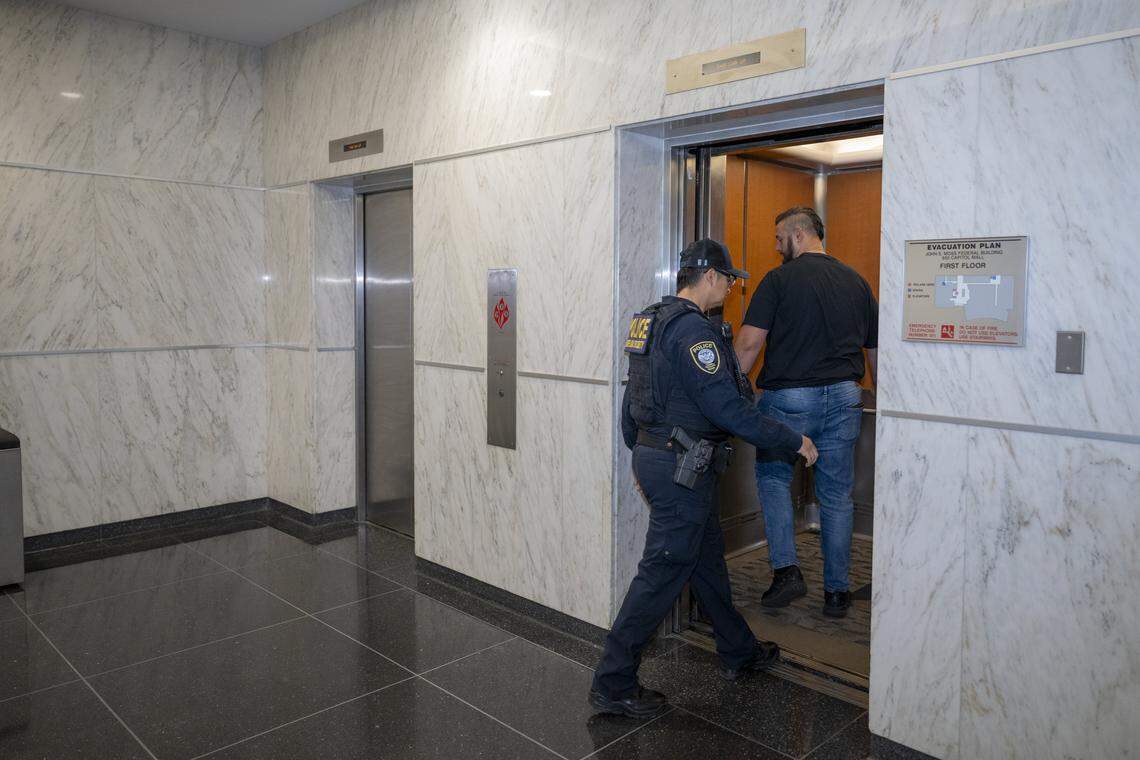 Federal authorities enter an elevator in the John E. Moss federal building in downtown Sacramento on June 12.