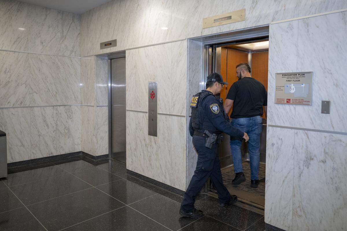 Federal authorities enter an elevator in the John E. Moss federal building in downtown Sacramento on June 12.