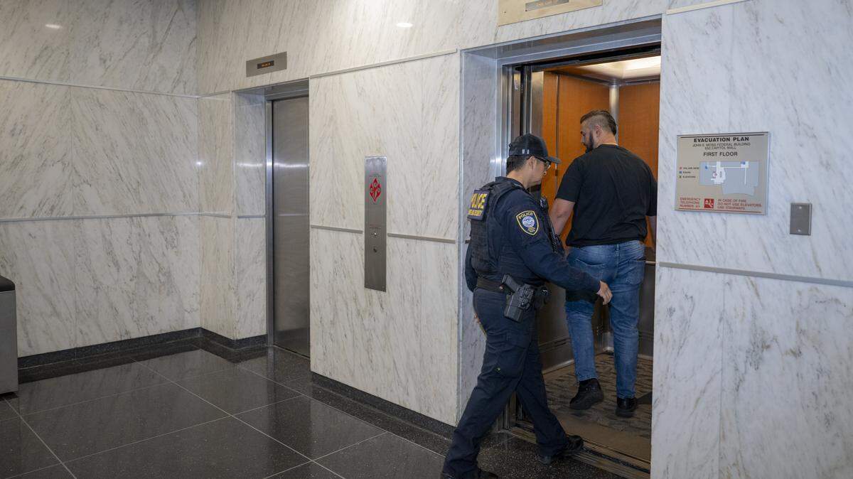 Federal authorities enter an elevator in the John E. Moss federal building in downtown Sacramento on Thursday, June 12, 2025.