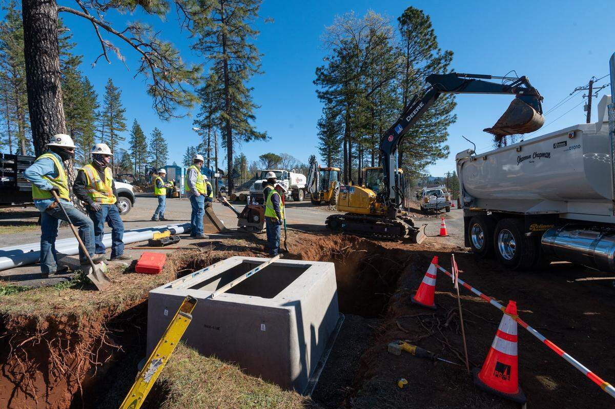 A PG&E crew buries pipes and power lines along Pearson Road on Feb. 17, 2022, in Paradise as part of a project to replace 200 miles of overhead wires in an effort to dramatically reduce wildfire hazards.