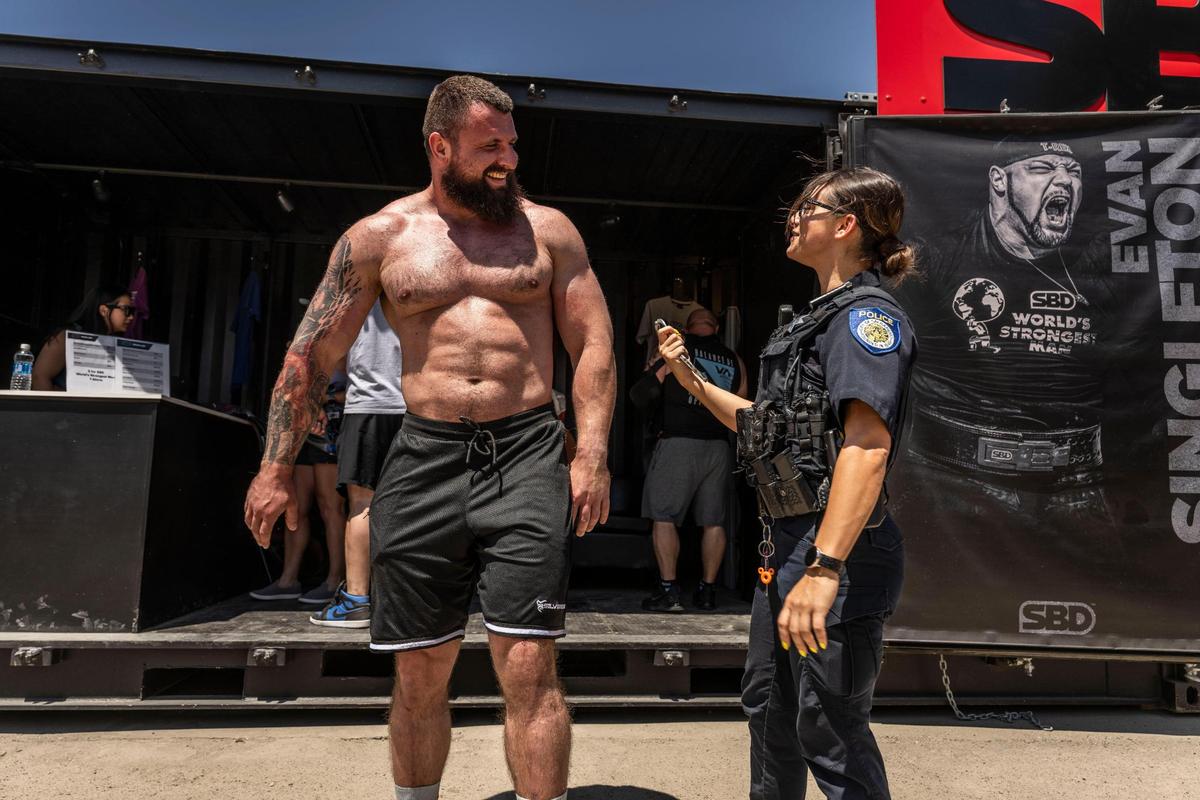 Pavlo Kordiyaka, of Ukraine, talks with Sacramento Police officer P. Powers during break in the World’s Strongest Man competition on Sunday, May 18, 2025, in Old Sacramento.