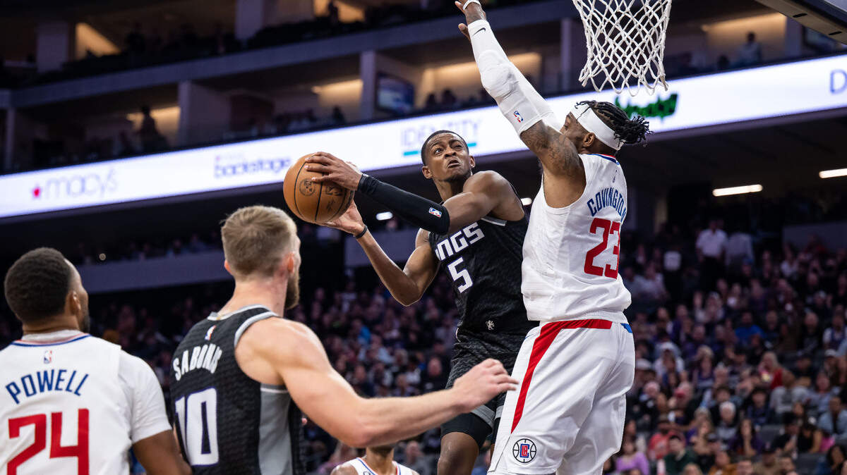 Sacramento Kings guard De’Aaron Fox (5) attempts two points as Los Angeles Clippers forward Robert Covington (23) defends during the second half of the NBA basketball game Saturday, Oct. 22, 2022, at Golden 1 Center in Sacramento.