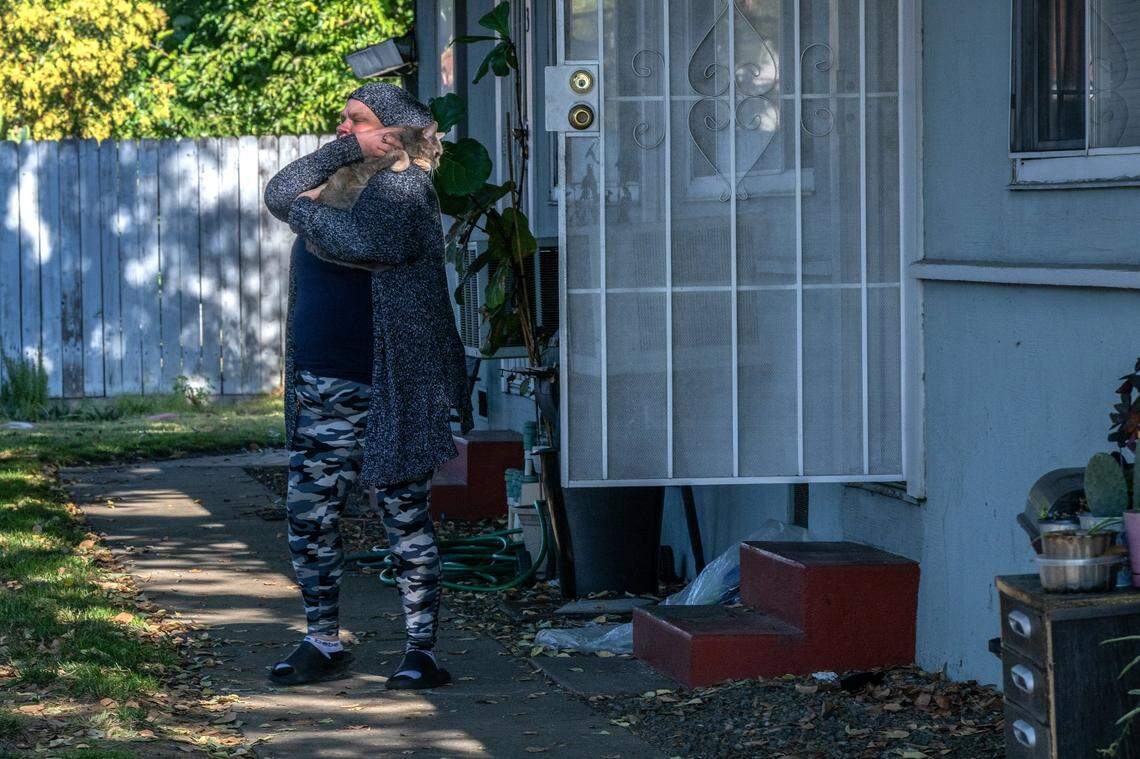 Kristi Phillips, 49, snuggles with her cat Macy on Monday Oct. 30, 2023, while waiting for the Sheriff’s deputies to evict her from the Sacramento apartment where she has been staying with her son. Her two youngest daughters live with their father nearby. After she lost her car, she has been struggling to get to work although she is still managing to get to some contracting jobs.