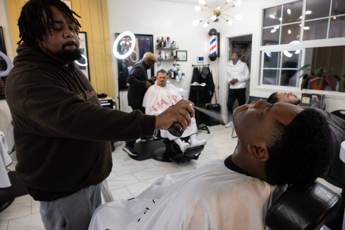Wayne “Paper Kutz” Threets adds the final touches to Grant High School student Amiere Lewis’ shave at HAIRitage Salon last month in Sacramento.