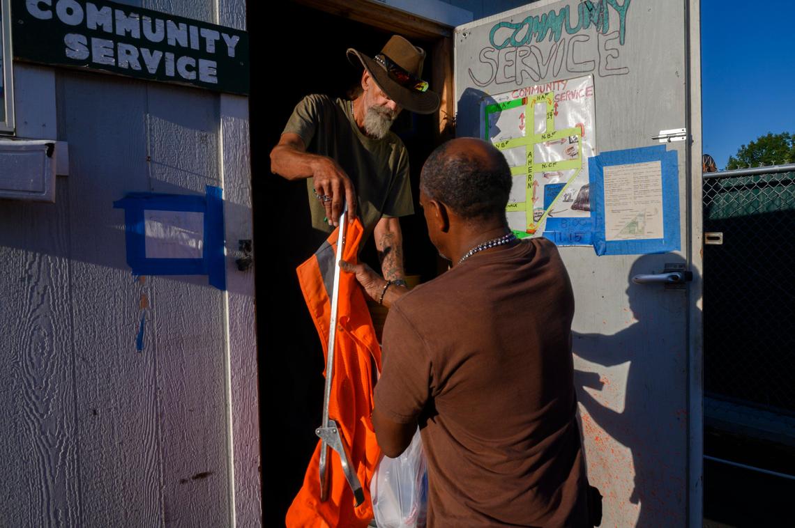 Joe Snyder issues a community service vest and a trash picker to Kevin King, 61, right, on Thursday, Sept. 26, 2019. Snyder supervises the homeless in the community service program so they can avoid incarceration and fines. The program originated at the Tommy Clinkenbeard Legal Clinic at Loaves & Fishes. Snyder was homeless for ten years before volunteering and that led to the full-time job he has had for the past eight years.