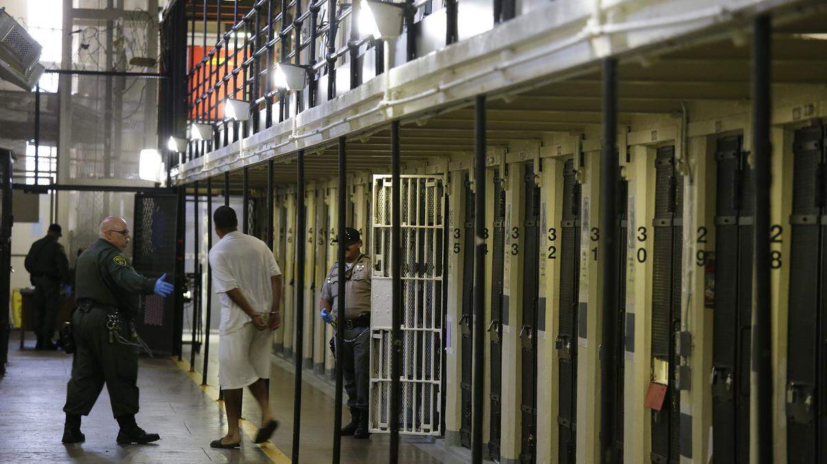 A condemned inmate is led out of his east block cell on death row at San Quentin State Prison in August 2016. The prison’s former chief psychiatrist received an $822,000 settlement, alleging he experienced retaliation after warning about risk in a mental health plan.