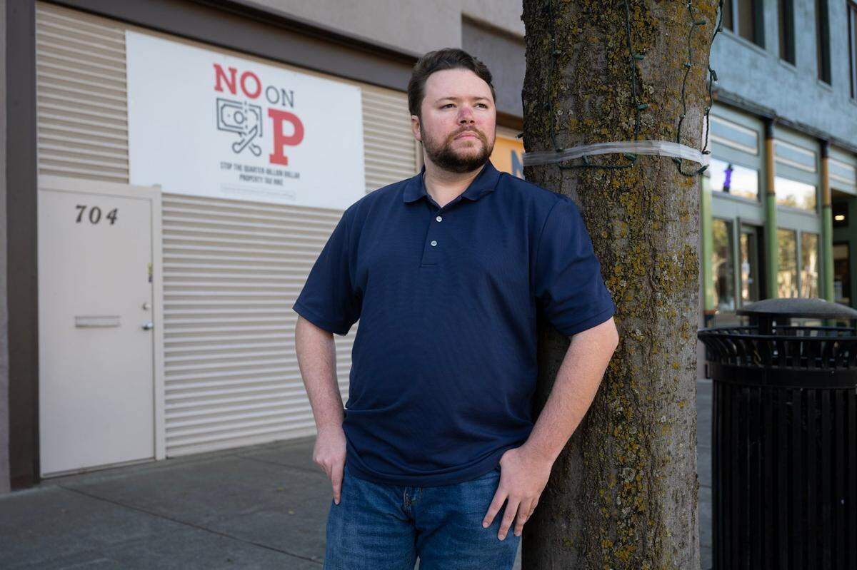 Former Woodland School Board trustee Jake Whitaker, a proponent of a school district bond measure, stands in front of opponent’s “No on P” sign on Monday in Woodland.