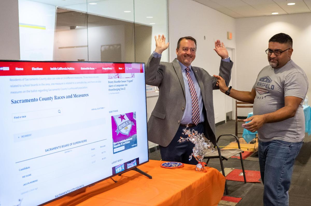 Pat Hume raises his arms celebrating holding a slim lead over Jaclyn Moreno during a secondary release of results in the Sacramento County Board of Supervisors District 5 race Tuesday, Nov. 8, 2022, at the Hume campaign office in Elk Grove.