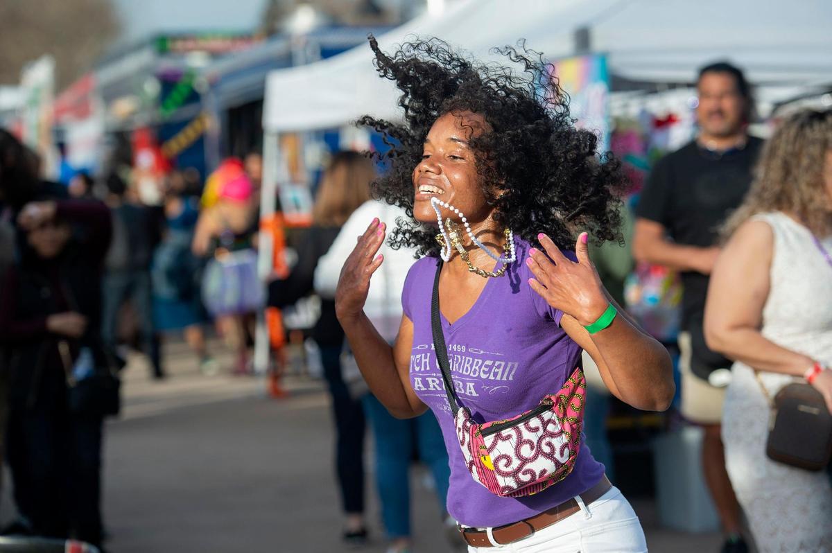 Azuri Whitlock, of San Francisco, dances to Ambitious Rhythm performing during the Mardi Gras celebration on Sunday, Feb. 19, 2023, in Old Sacramento.