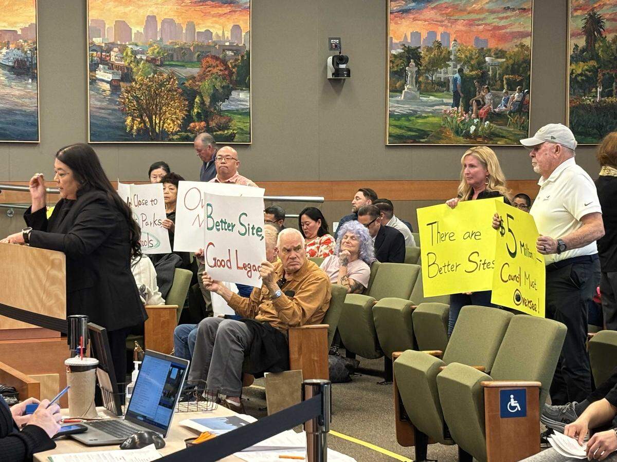 North Natomas residents on Tuesday hold signs opposing the micro-community at the corner of Arena Boulevard and El Centro Road during a Tuesday Sacramento Council meeting.
