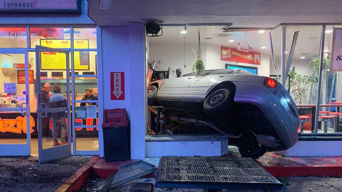A car is seen wedged near the entrance to Suzie Burger on 29th and P streets in midtown Sacramento on Monday, Dec. 12, 2022. The driver of the vehicle was hospitalized and the cause of the crash was unknown.