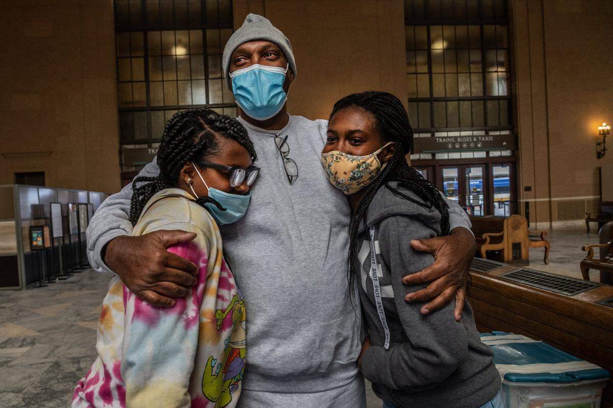 Quinton Watts holds his daughters tightly, Daisha Watts, 19, left, and Daishana Watts, 17, at the Sacramento Valley Station on Wednesday, Feb. 3, 2021. The last time he’d held them was when they were little girls, almost 12 years ago. He was released from California State Prison-Solano in Vacaville earlier that morning. “I just wanted to go home and see my beautiful girls there, that’s all I wanted,” he said. “It’s a dream come true.”
