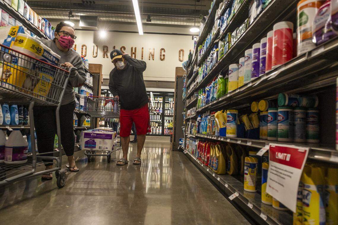 Customers gaze at the selection of disinfectant wipes on opening day at the new Raley’s in South Land Park in Sacramento on Wednesday, April 15, 2020. While the shelves were fully stocked, they were limited to a maximum of two items per family per visit on essential items such as paper products.