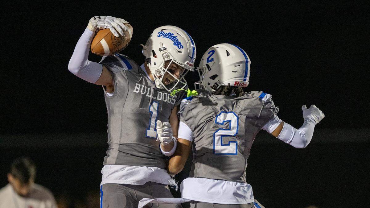 The Folsom Bulldogs’ Jameson Powell (2) celebrates with teammate Rob Larson (1) after Larson scored a touchdown In the first half against the Granite Bay Grizzlies on Friday in Folsom.