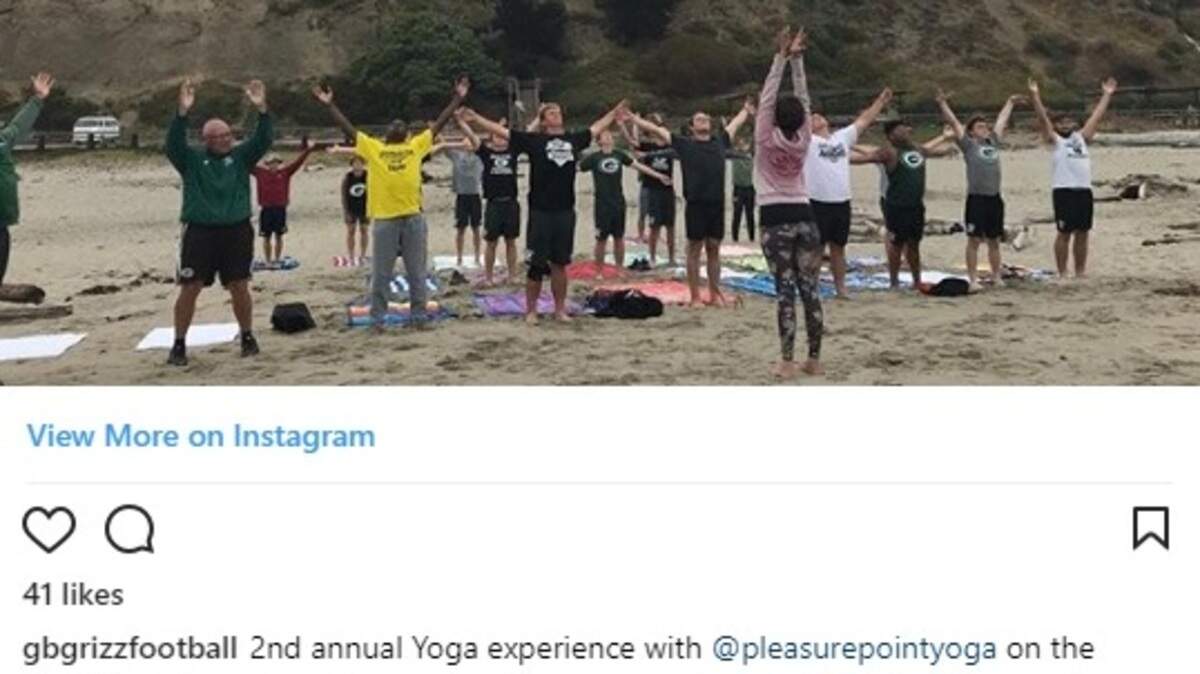 Granite Bay High School football players perform yoga poses at the beach.