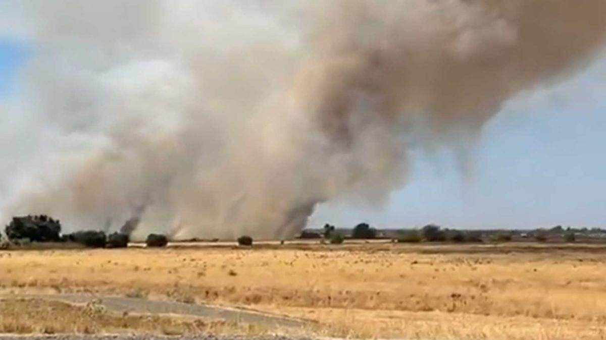 Smoke is seen Tuesday, Aug. 12, 2025, from the Power Line Fire on Garden Highway and Power Line Road near Sacramento International Airport. Firefighters halted forward progress after it burned 220 acres.