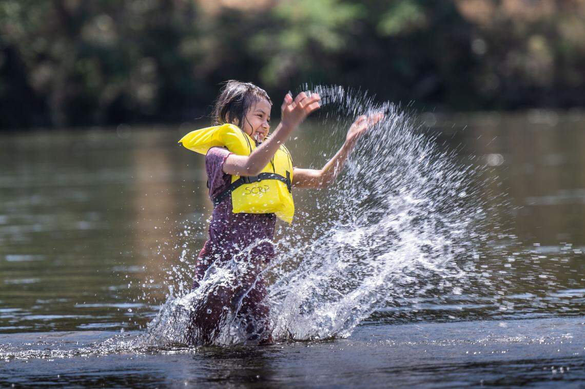 Tajala Jambdi, 7, of Sacramento splashes water while wearing a life jacket on the American River at River Bend Park in Carmichael on Thursday, June 27, 2024. A representative from the Drowning Accident Rescue Team said swimmers are sometimes confused on how to properly wear a life jacket. 