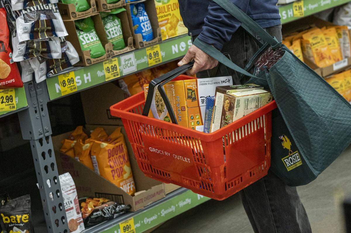 A shopper holds a shopping basket with groceries inside a grocery store in San Francisco on May 2, 2022. MUST CREDIT: Bloomberg photo by David Paul Morris.