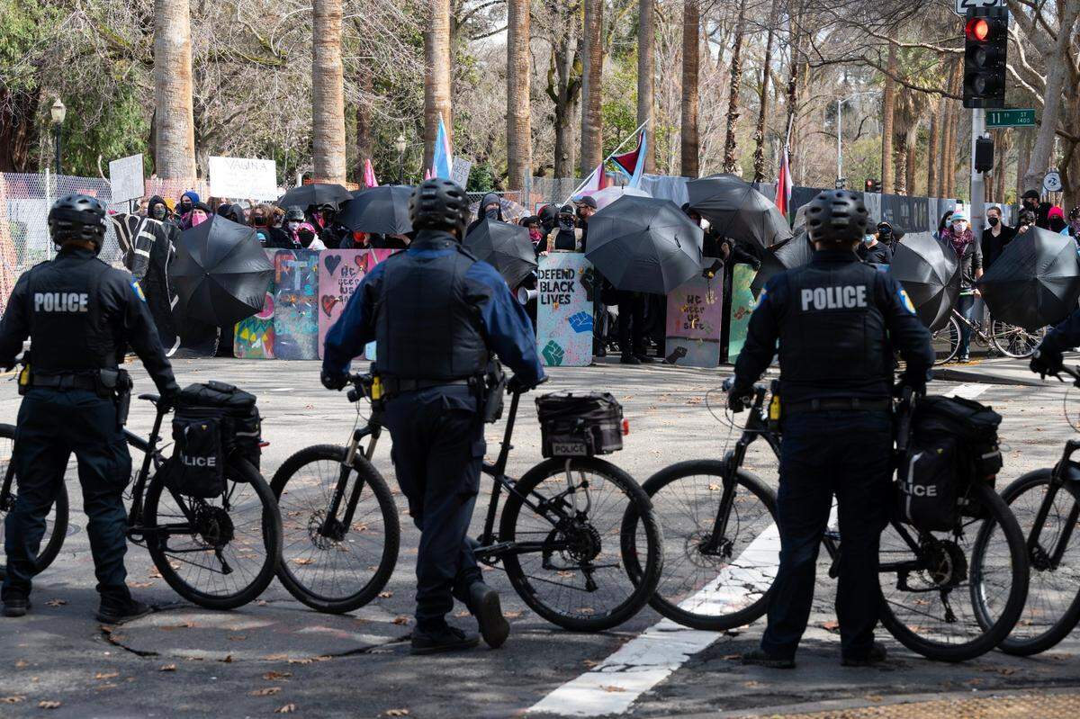 Sacramento Police monitor the Pride Was A Riot trans activist group on N Street as a Detransition Awareness Day rally that organizers call the “biggest gathering of individuals harmed by gender ideology to date” takes place at the state Capitol in Sacramento, Friday, March 10, 2023.