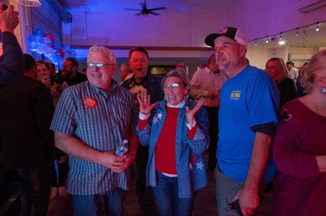 Redding resident Karen Lawrence, center, shows excitement as results in the Shasta Board of Supervisors District 2 recall election are refreshed on Tuesday night, while she stands with replacement candidates Tim Garman, left, and Dale Ball, right, at Country Strong Fitness in Palo Cedro. The recall was passing late Tuesday, with Ball leading Garman to fill the seat.