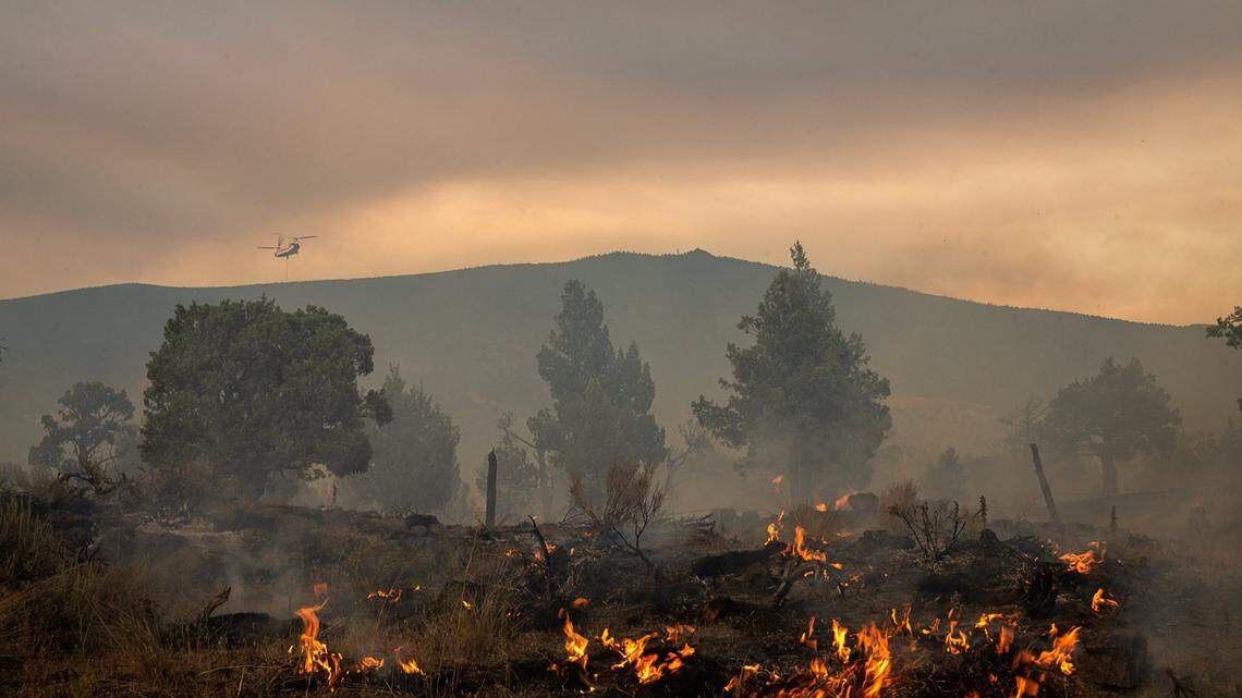 An air attack helicopter drops water on hot spots battling the Lava Fire on Tuesday, June 29, 2021, outside of Weed in Siskiyou County. A contract helicopter working the firehad to make an emergency landing in Lake Shastina.