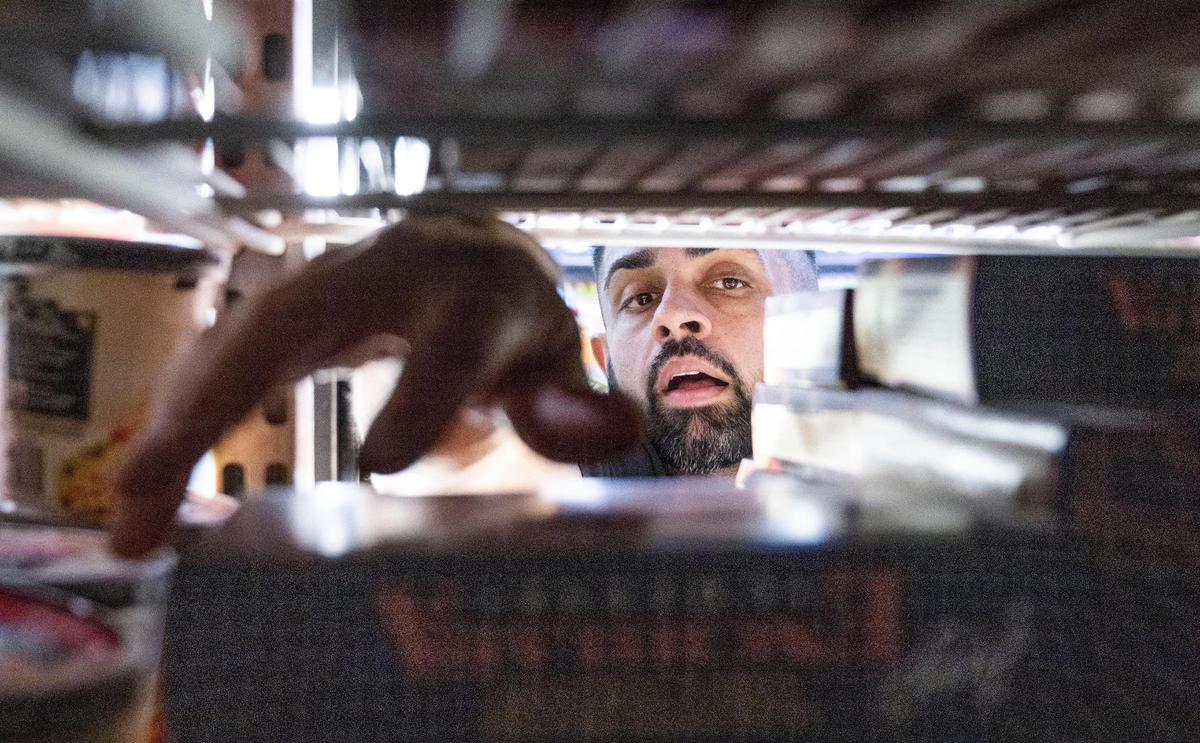 Preet Singh, 33, owner of Pacific Market on P Street in midtown Sacramento works at his store on Wednesday, Oct. 12. “Anything you need, we basically will go out of our way and make it happen for our customers,” he said. At the front of the cash register is a yellow notepad, labeled, “What Can Pacific Market Get For You?” where customers can scribble down items they want to see stocked on the shelves.