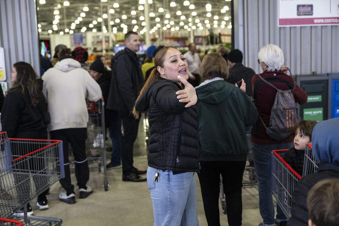 Lorena Martinez, a front-end supervisor at Costco, directs customers during a grand opening of their new store on Baseline Road in Roseville on Friday. The large demand for specialty liquor required two lines – one for liquor and one for all other products. 