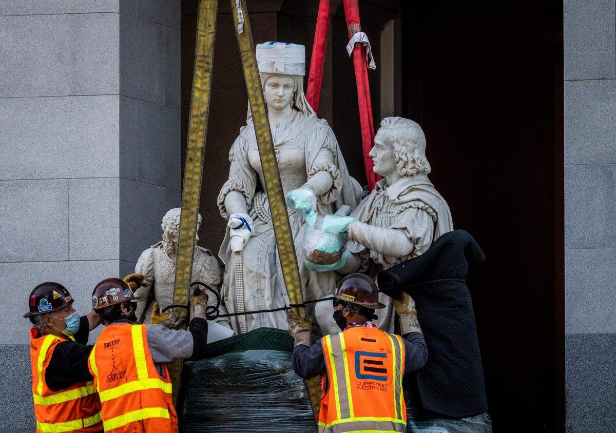 Workers move a 5-ton statue of Christopher Columbus and Queen Isabella to a flatbed truck at the west steps of the Capitol in downtown Sacramento on Tuesday, July 7, 2020. The statue was removed from the Capitol’s rotunda, which was its home since 1883, two weeks after Legislature leaders announced it would come down.