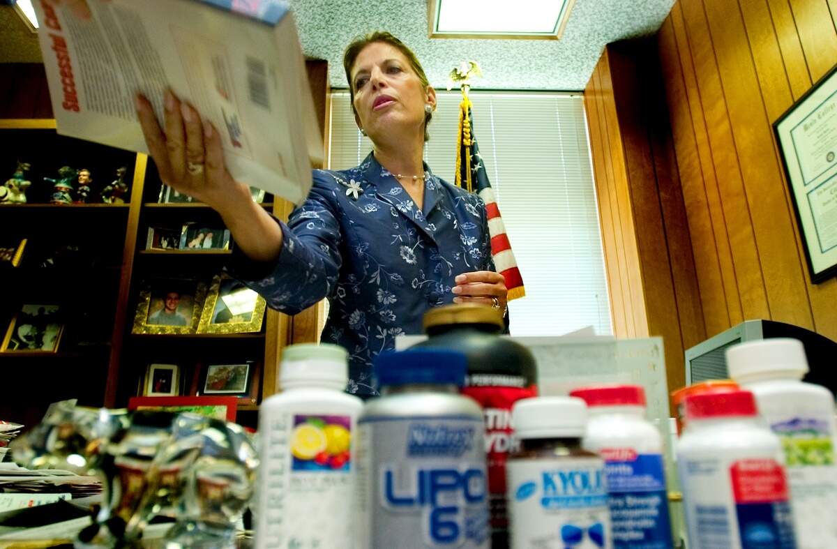 State Sen. Jackie Speier D-Hillsborough, reaches for a coaching book as she talks in her state Capitol office Thursday, July 14, 2005, about the potential conflict of interest for Gov. Arnold Schwarzenegger to receive millions of dollars from body building magazines and then vetoing a bill that would restrict supplement use by high school athletes.