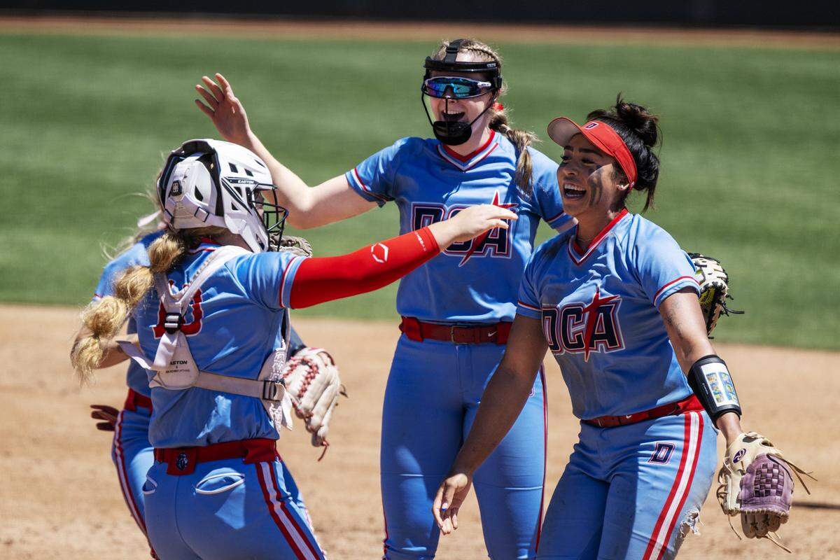 The Destiny Christian Academy Lions' Ayla Tuua, right, Ella Dossey (10) and other teammates celebrate following the 4-1 victory over the Vanden Vikings on Saturday in the CIF Sac-Joaquin Section Division III softball championship at Sacramento State.