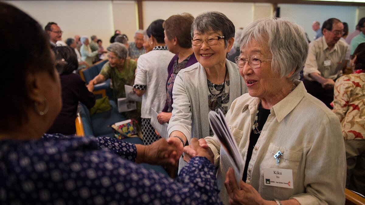 Shigeri Okamotob and Kiko Ito greet Rose Williams at the Sacramento Japanese Methodist Church, one of the oldest churches in Sacramento, that celebrated its 125th birthday Sunday.