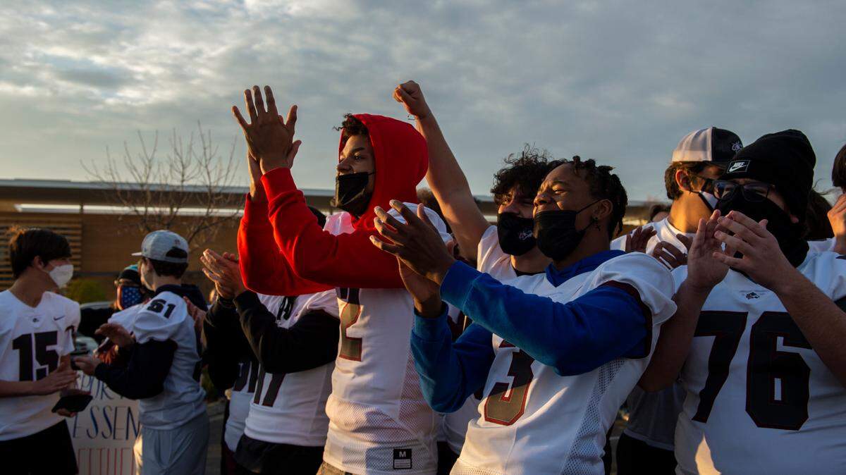 Woodcreek High football teammates and cousins, Amari Taylor, 17, center, and Dashawn Bradley, 16, center right, applaud as a fellow athlete speaks during a “Let Them Play” rally in Rocklin, one of a series of rallies across California on Friday, Jan. 15, 2021, to push for the resumption of high school sports during the coronavirus pandemic. Many youth and adult sports leagues are starting play in Placer County.