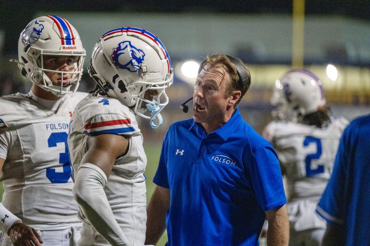 Folsom Bulldogs head coach Paul Doherty talks with Isaiah Williams (4) after Williams was penalized for excessive celebration following a touchdown against the Grant Pacers in the second half on Saturday.