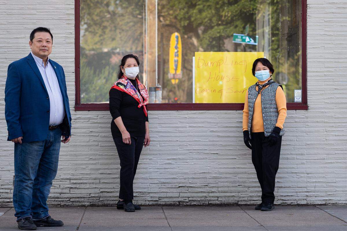 Partners in the new Dumpling House, from left, Tony Lin of Elk Grove, Linda Liu of West Sacramento and Regina Yin of Solano County, stand outside their planned restaurant at 2330 J St. on April 11 in midtown Sacramento. Their business, unlike many others on the 2200 and 2300 block of J Street, is under renovation ahead of opening for the first time. Liu said her contractors have been able to continue working under the new restrictions put in place to slow the spread of the new coronavirus, and have been donning masks as when they come in.