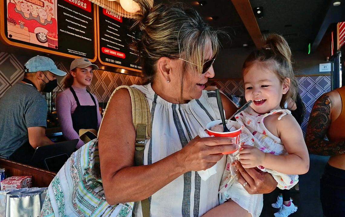 Patti Tigri of Wilton and her granddaughter Taylor leave Salt & Straw with the first scoop of ice cream – strawberry honey balsamic with black pepper – sold at the chain’s first Sacramento-area location on its opening day Friday, Sept. 2, 2022, during the city’s blistering heat wave. The ice cream chain is known for its zany flavors.