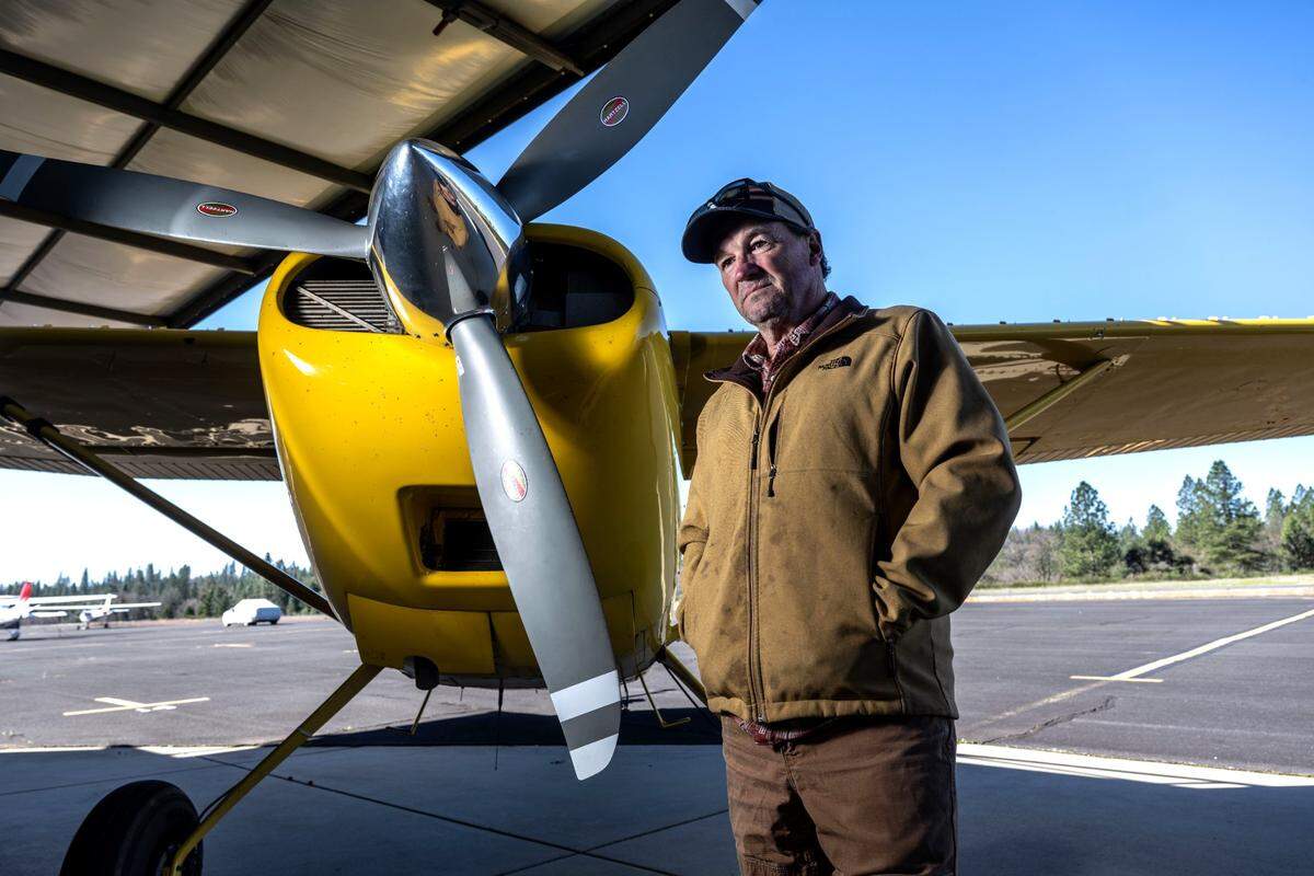 Pilot Scott Herring stands next to one of his airplanes at the Georgetown Airport on Friday. He has several businesses at the airport, including Airfilm Camera Systems, which makes of aircraft mounts for imaging systems. Herring and other pilots say that tree growth near the runway has made for dangerous conditions.