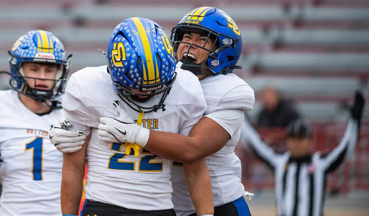 Sutter Huskies running back Losi Asiata (2) congratulates  running back Max Bringgold (22) after his fourth-quarter touchdown against the Casa Roble Rams in the CIF Sac-Joaquin Section Division V championship at Hughes Stadium in Sacramento on Friday.