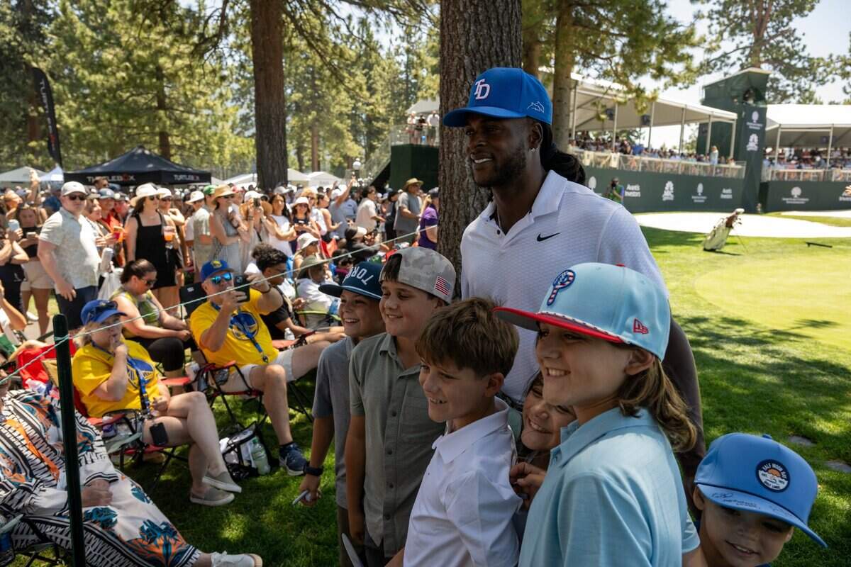 The Los Angeles Rams’ Davante Adams poses for photographs with fans during the American Century Championship celebrity golf tournament at Edgewood Tahoe Resort in Stateline, Nev., on Friday, July 11, 2025.