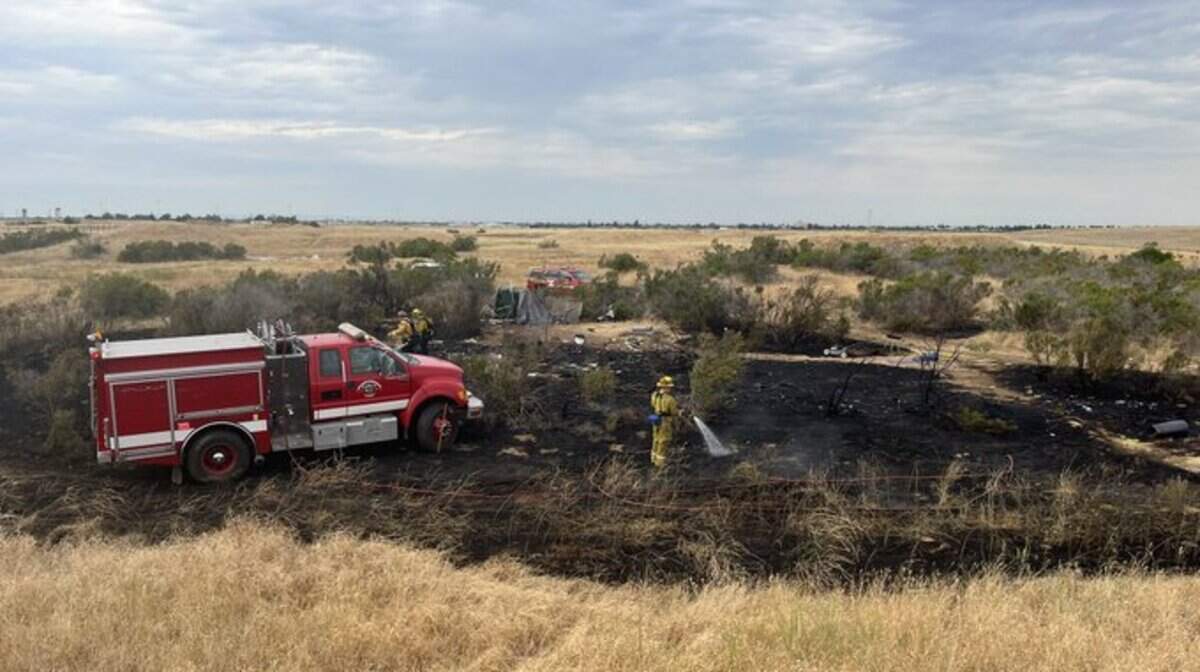 Sacramento Metropolitan Fire District crews extinguish a vegetation fire at a Rancho Cordova homeless encampment on Aug. 1, 2022.