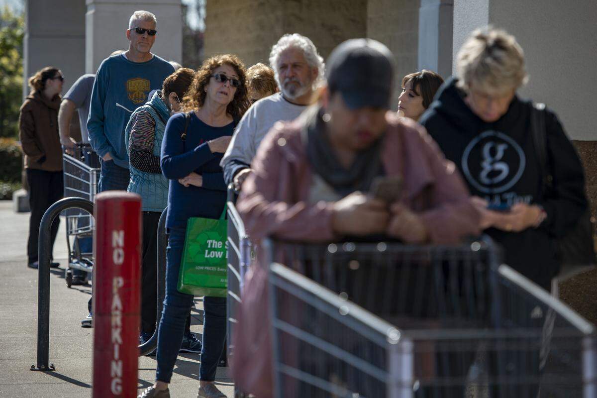 Customers wait on line outside of a Winco grocery store on Fairway Drive in Roseville on Friday, March 20, 2020, as the store tries to limit the number of people inside to help slow the spread of the coronavirus. California Gov. Gavin Newsom on Thursday ordered state residents to stay home during the pandemic, with the exception of essential activities.