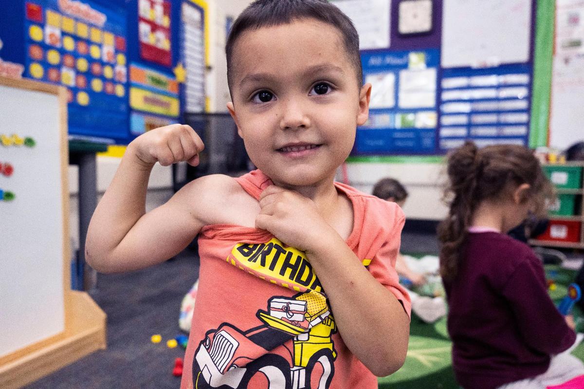 Muhammad Ali Imonkulor, de cinco años, flexiona sus músculos en la Primaria Thomas Kelly mientras participa en el programa de preescolar de transición universal, el miércoles 26 de octubre de 2022, que se está implementando gradualmente en todo el estado, gracias al asambleísta Kevin McCarty. El programa está abierto a niños de cuatro años. Les ayuda a prepararse para el preescolar, especialmente porque muchos alumnos no asistieron a ninguna escuela preescolar debido a la pandemia. En esta clase en concreto, solo dos de los 23 alumnos fueron a preescolar.