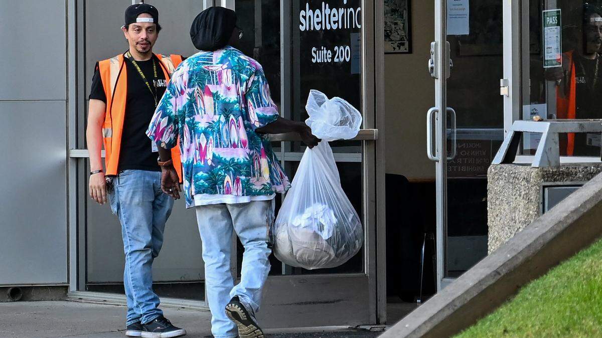 Jacob Ikeokwu, 62, walks past a security guard at Shelter Inc., a non-profit homeless shelter in Sacramento’s River District where he has been staying for the past two weeks, to do his laundry on Tuesday, May 7, 2024. Jacob is still trying to use his Housing Choice (formerly known as Section 8) voucher. “I think they need to speed up a bit because we are really, really dying,” he said.