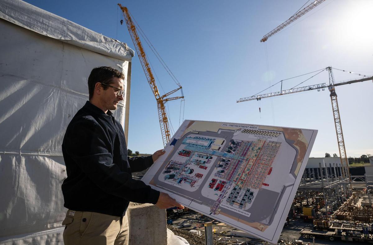Nik Weinberg-Lynn, Phillips 66 Rodeo renewable energy manager, holds a poster of plans in January amid ongoing construction, part of the refinery’s plans to change from processing crude oil to renewable fuels.