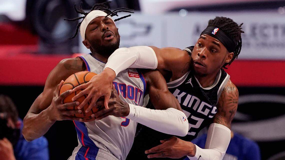 Sacramento Kings center Richaun Holmes (22) reaches in on Detroit Pistons forward Jerami Grant (9) during the first half of an NBA basketball game, Friday, Feb. 26, 2021, in Detroit. (AP Photo/Carlos Osorio)