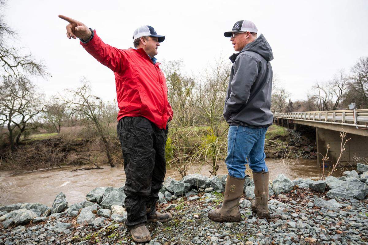 Leland Schneider, left, a Reclamation District 800 trustee, talks with Wilton farmer Brad Jones on Monday while they stand on the Cosumnes River levee that was re-enforced last week. Schneider said they need $50 million to fix the levee permanently on a $500,000 budget.