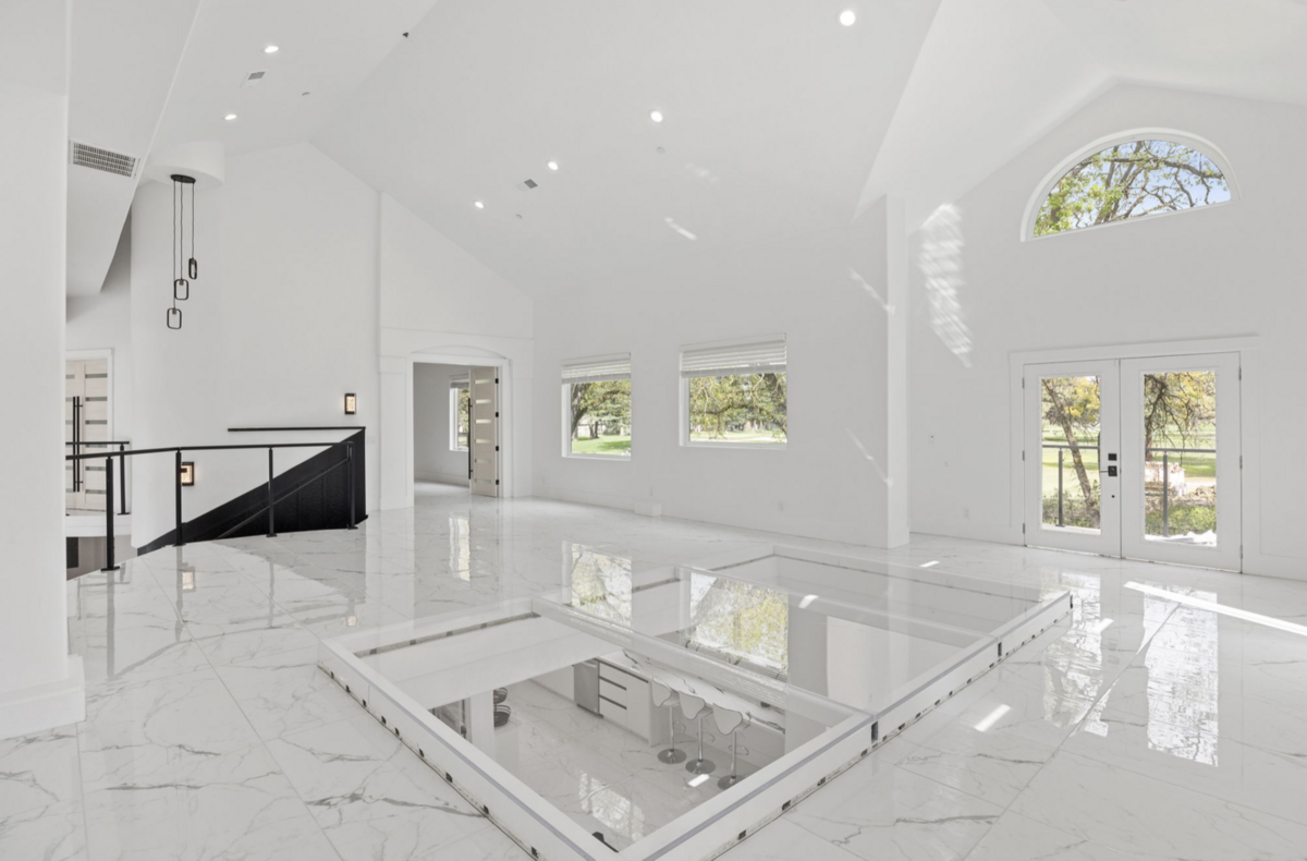 A 14-foot glass dance floor upstairs looks down on the living room and kitchen areas.